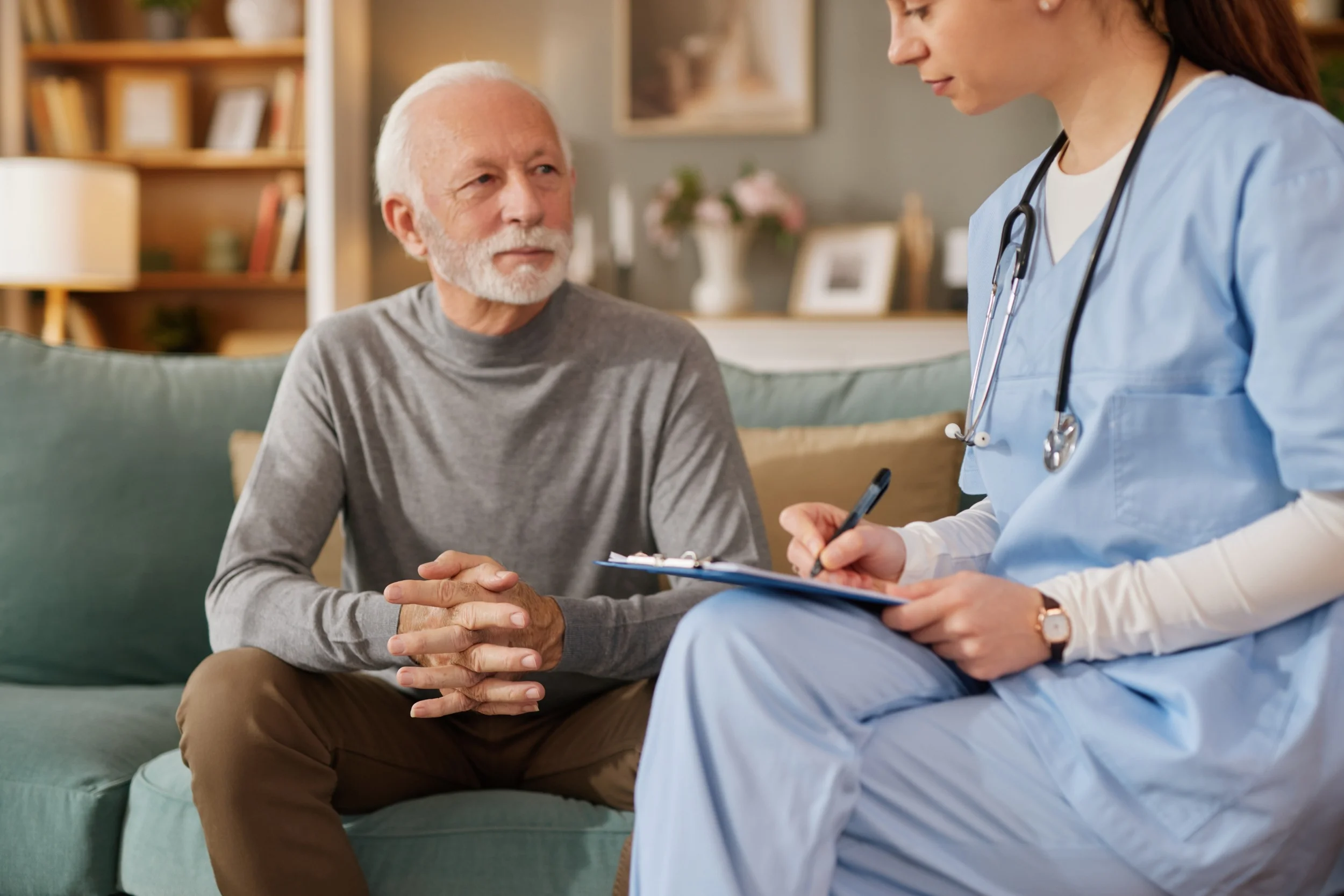Nurse consulting elderly man at home