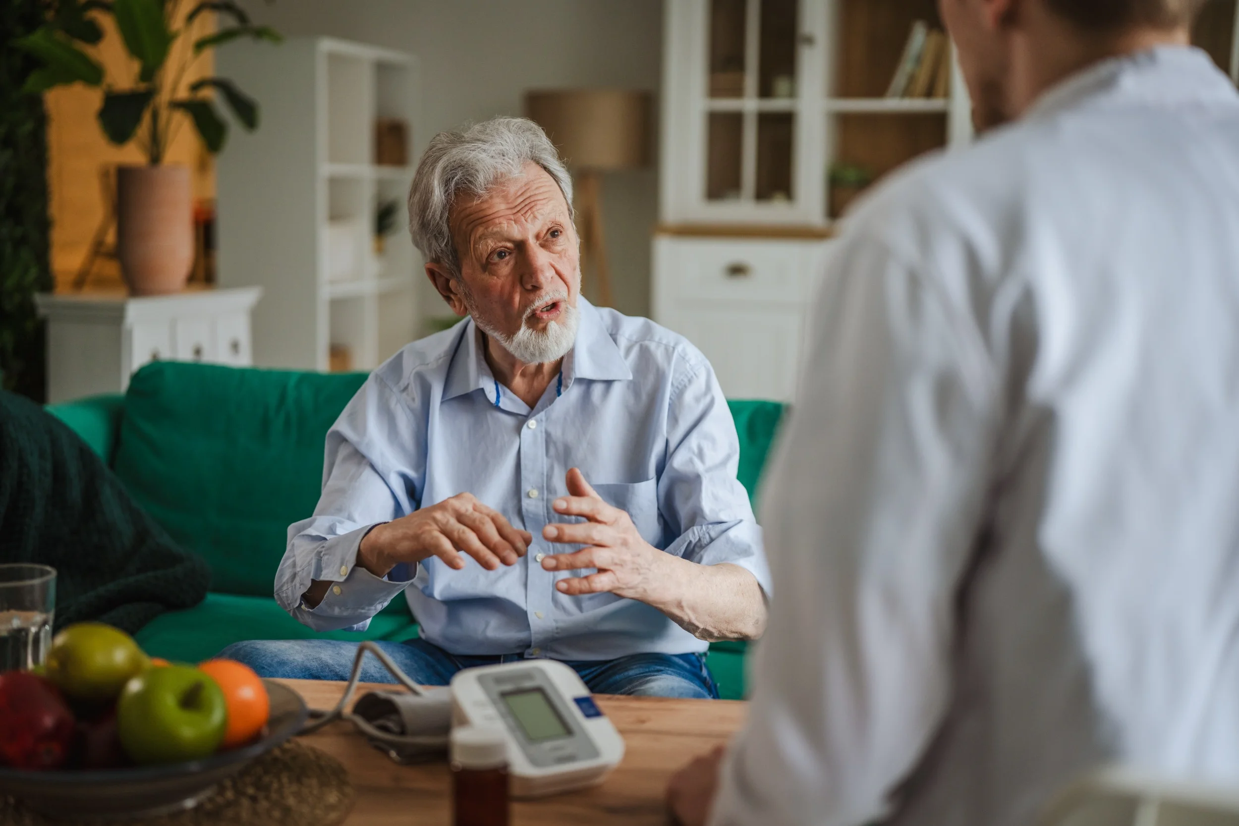 Elderly man consulting doctor at home visit