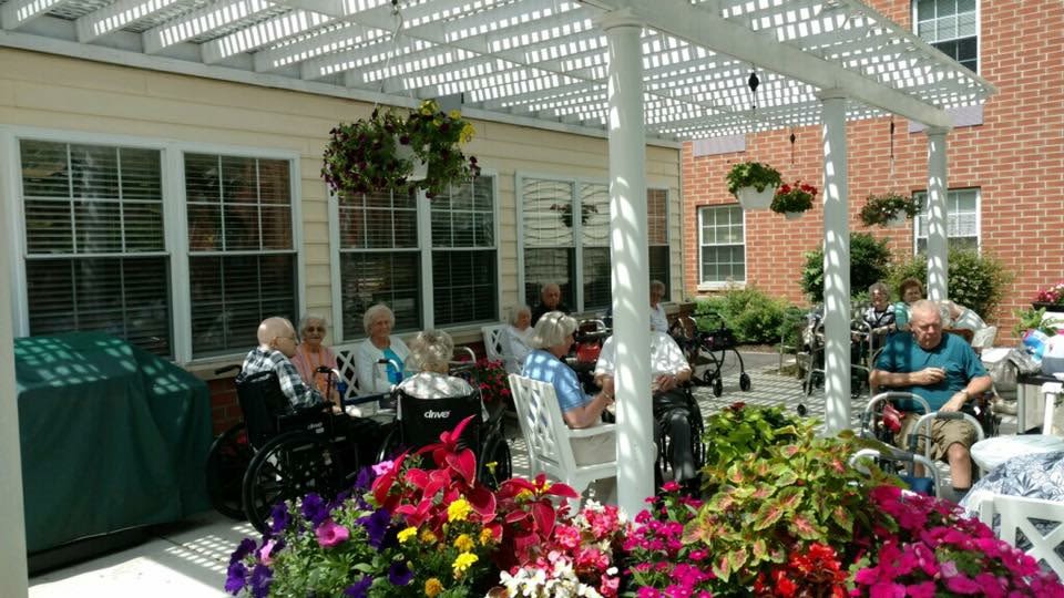 Seniors relaxing under pergola in garden courtyard