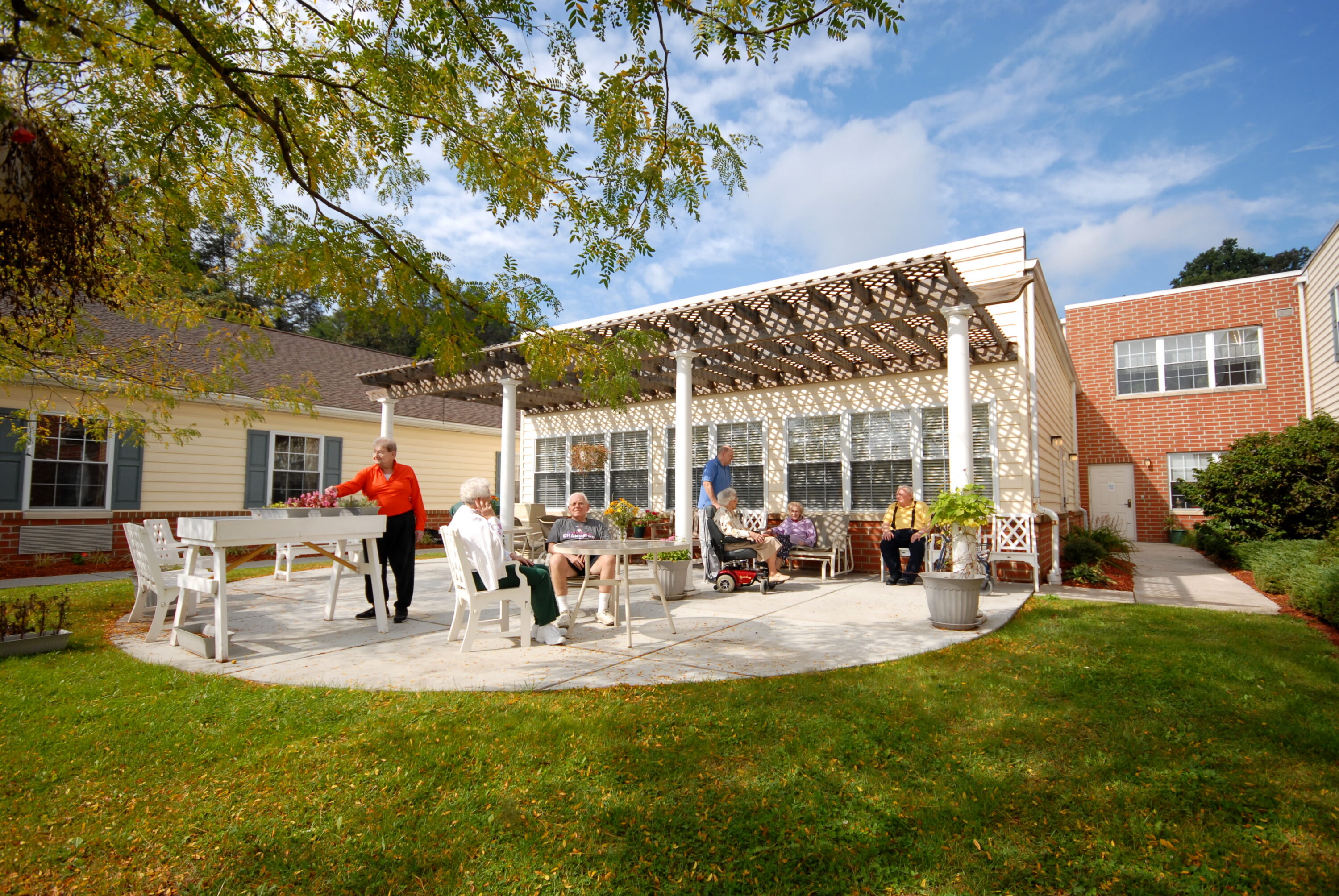 Seniors relaxing in sunny courtyard at care home