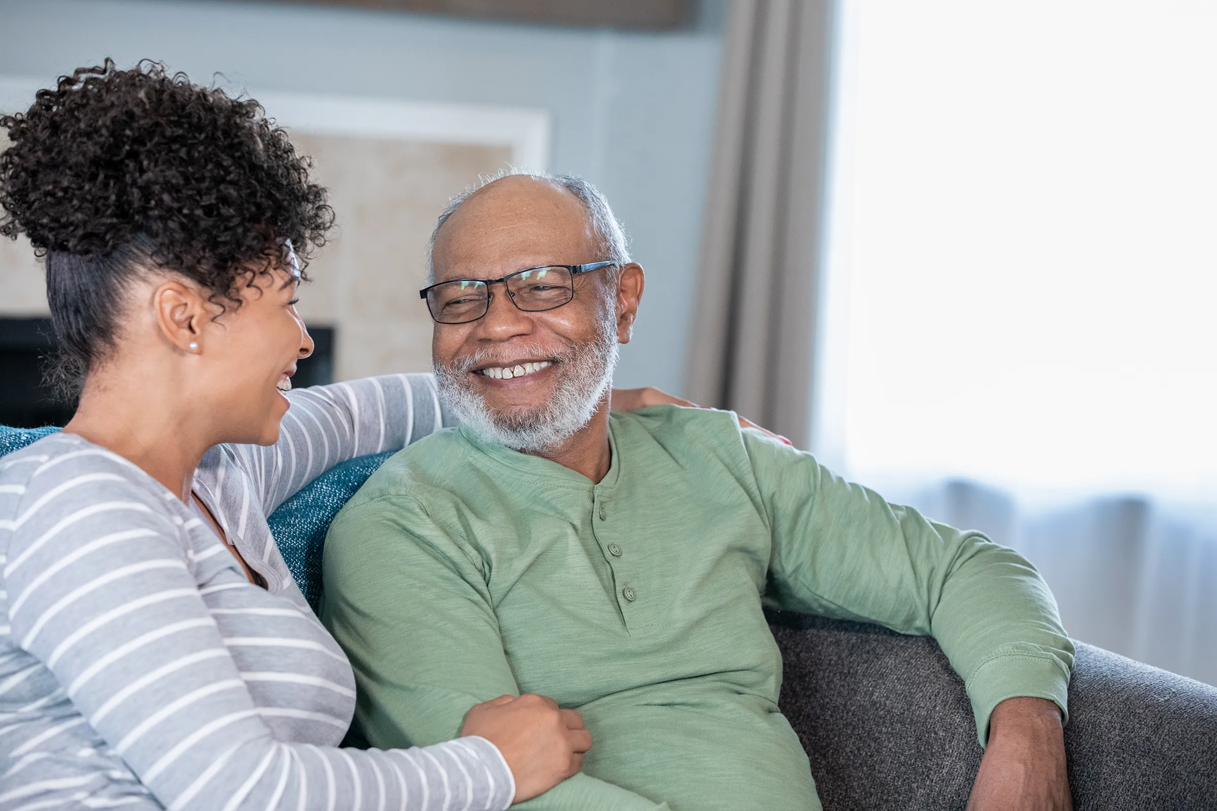 Smiling older man and woman talking on couch